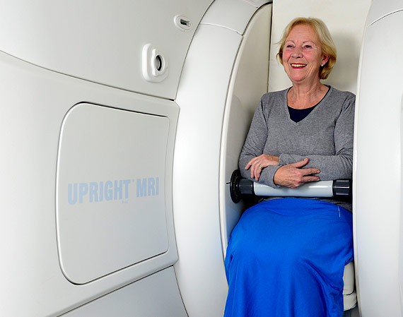An image showing how a patient sits in an open MRI scanner